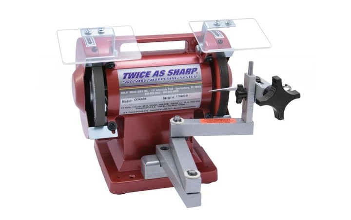 Red scissor-sharpening machine with a tool support and protective guards